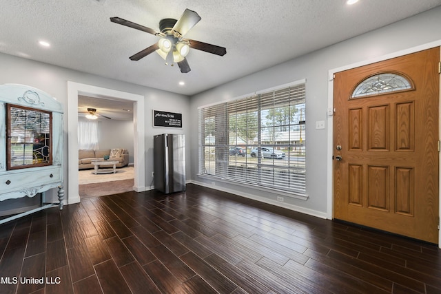 foyer entrance featuring dark wood finished floors, a textured ceiling, and recessed lighting