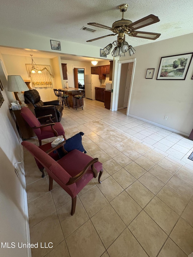 1717 Cherokee St, Pascagoula, MS 39581 - living room with light tile patterned floors, a textured ceiling, ceiling fan, and a chandelier