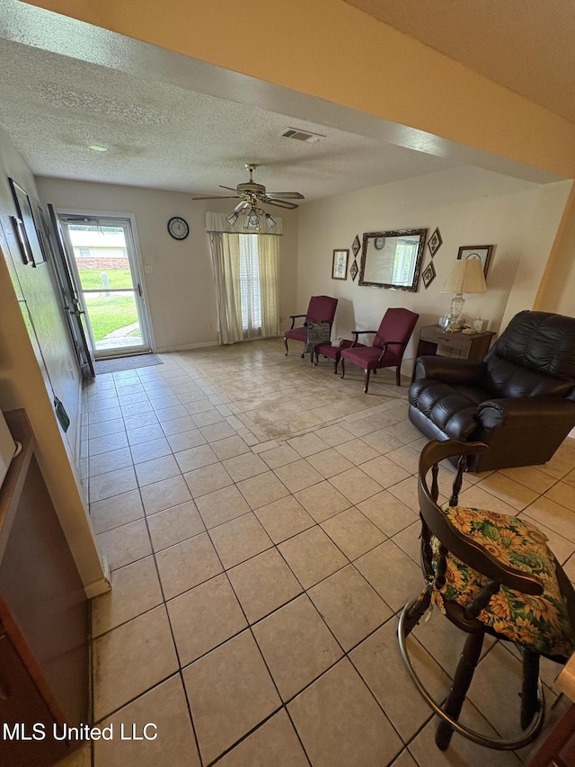 1717 Cherokee St, Pascagoula, MS 39581 - living room featuring light tile patterned floors, a textured ceiling, and a ceiling fan