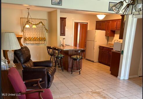 1717 Cherokee St, Pascagoula, MS 39581 - kitchen featuring freestanding refrigerator, a kitchen breakfast bar, a peninsula, and light countertops