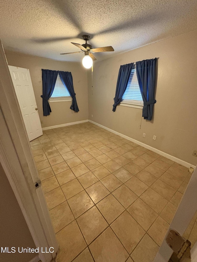 1717 Cherokee St, Pascagoula, MS 39581 - empty room with light tile patterned floors, a textured ceiling, and ceiling fan