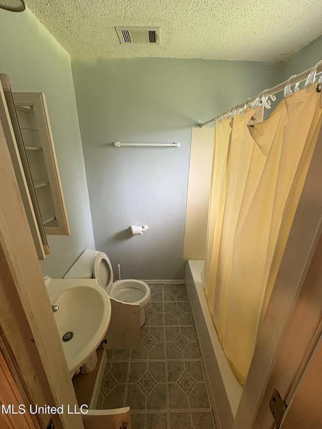 1717 Cherokee St, Pascagoula, MS 39581 - bathroom with a textured ceiling, shower / bath combo, and tile patterned floors