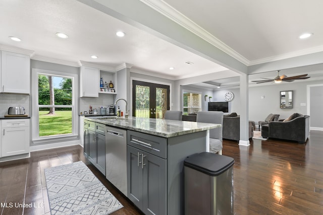 17508 John Cumbest Rd, Moss Point, MS 39562 - kitchen featuring dishwasher, a sink, white cabinets, a center island with sink, and backsplash