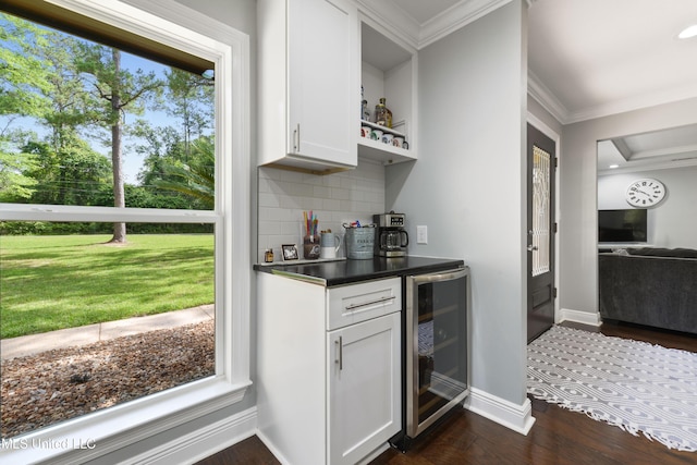 17508 John Cumbest Rd, Moss Point, MS 39562 - indoor dry bar with wine cooler, crown molding, decorative backsplash, dark wood finished floors, and baseboards