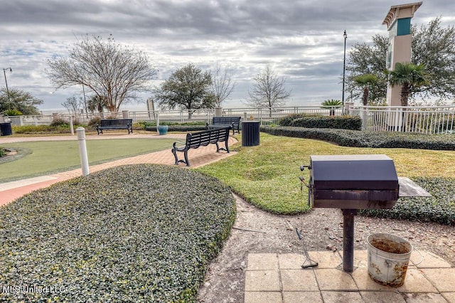 view of home's community with fence and a yard