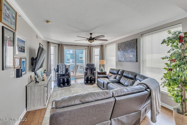 living room with ceiling fan, a textured ceiling, ornamental molding, and light hardwood / wood-style flooring