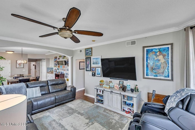 living room with visible vents, ornamental molding, decorative columns, baseboards, and a ceiling fan