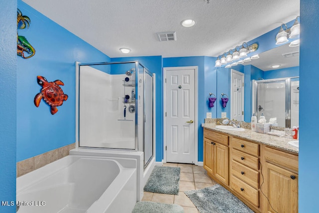 bathroom featuring vanity, independent shower and bath, a textured ceiling, and tile patterned floors