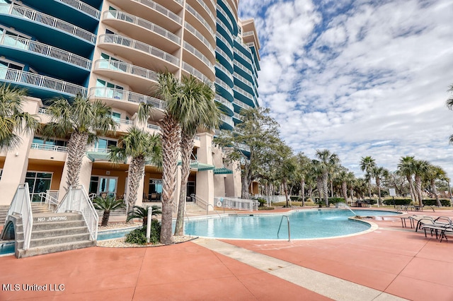 view of swimming pool featuring pool water feature and a patio area