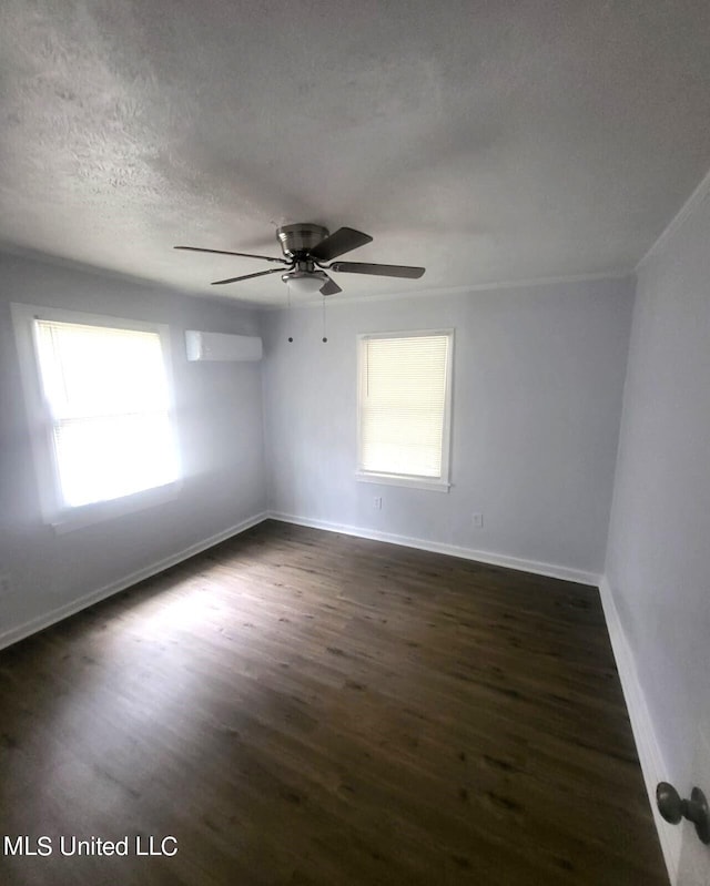 spare room featuring a textured ceiling, ceiling fan, a wealth of natural light, and dark hardwood / wood-style flooring