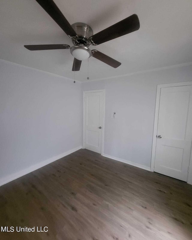 spare room featuring dark wood-type flooring and ceiling fan