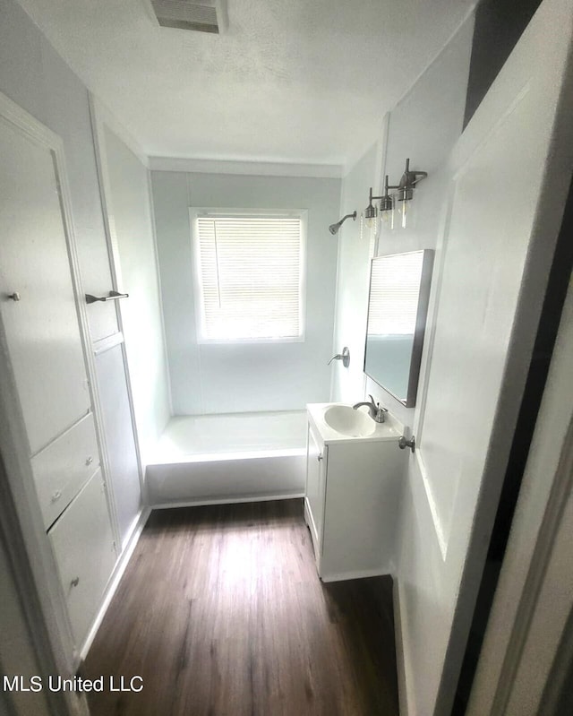 bathroom featuring vanity, bathing tub / shower combination, and wood-type flooring