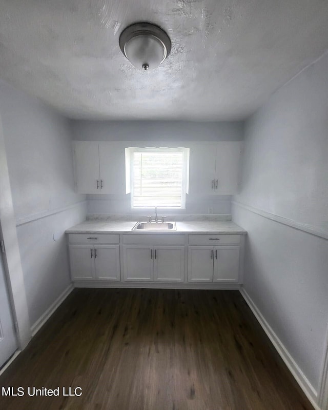 kitchen featuring white cabinets, sink, and dark wood-type flooring