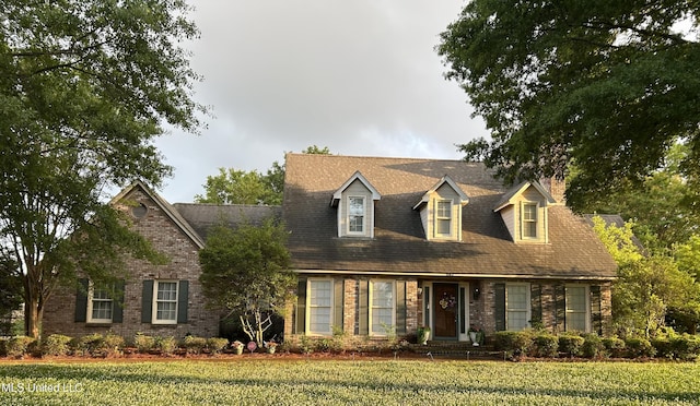 502 Frederick Dr, Cleveland, MS 38732 - cape cod home featuring a front yard, a chimney, and brick siding