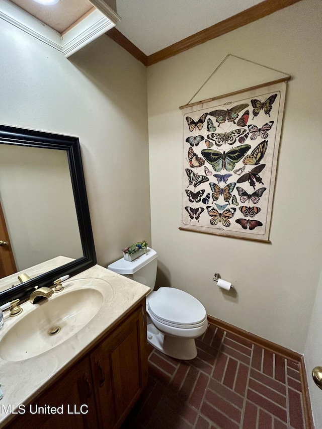 502 Frederick Dr, Cleveland, MS 38732 - half bathroom with brick flooring, crown molding, toilet, vanity, and baseboards