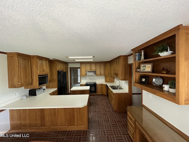 502 Frederick Dr, Cleveland, MS 38732 - kitchen with black appliances, a sink, under cabinet range hood, a textured ceiling, and light countertops