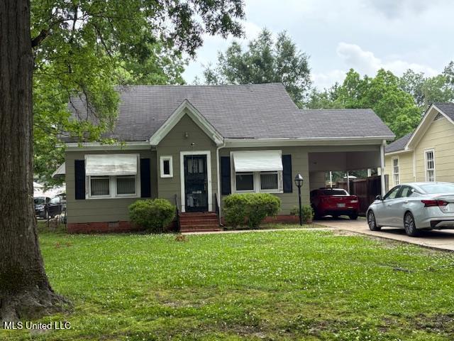 507 W Jefferson Ave, Greenwood, MS 38930 - view of front facade featuring an attached carport, a front lawn, driveway, crawl space, and roof with shingles