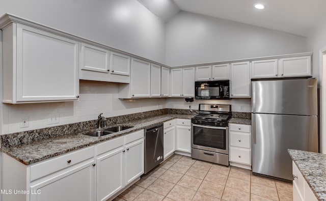 603 Charmant Pl, Ridgeland, MS 39157 - kitchen featuring appliances with stainless steel finishes, light tile patterned flooring, high vaulted ceiling, dark stone countertops, and recessed lighting