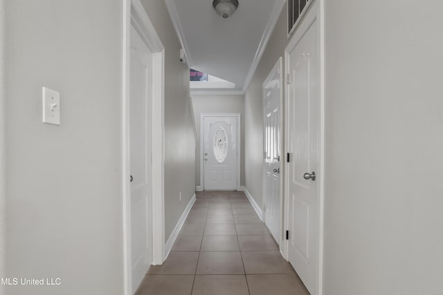 hall featuring crown molding and light tile patterned floors