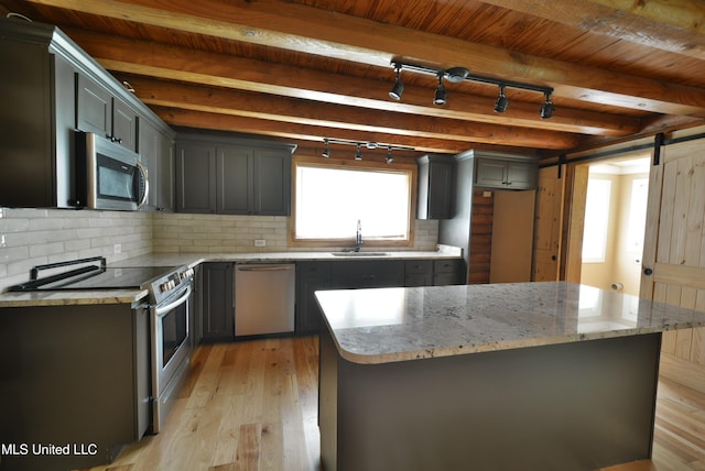 3490 Sherrod Rd, Nesbit, MS 38651 - kitchen featuring appliances with stainless steel finishes, a sink, plenty of natural light, a barn door, and beamed ceiling