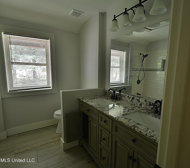 3490 Sherrod Rd, Nesbit, MS 38651 - bathroom featuring a tile shower, toilet, baseboards, and double vanity
