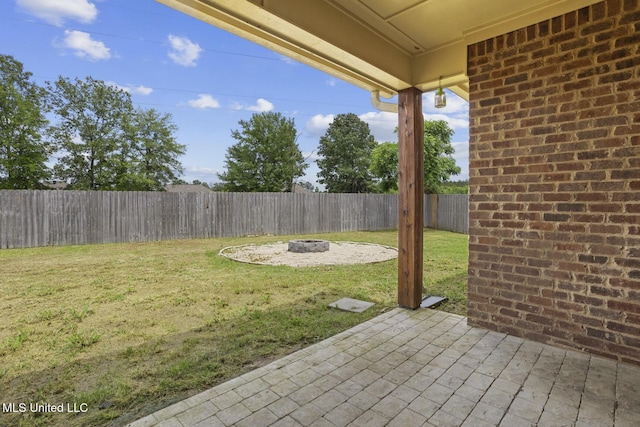 view of yard featuring an outdoor fire pit and a patio