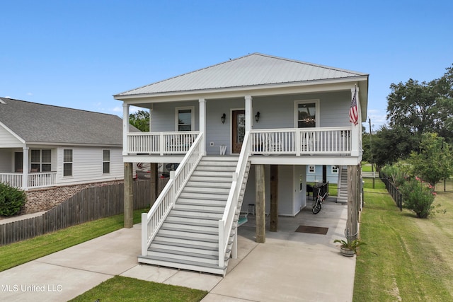 coastal home featuring covered porch and a front yard