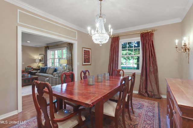 dining space featuring crown molding, a healthy amount of sunlight, hardwood / wood-style floors, and a chandelier