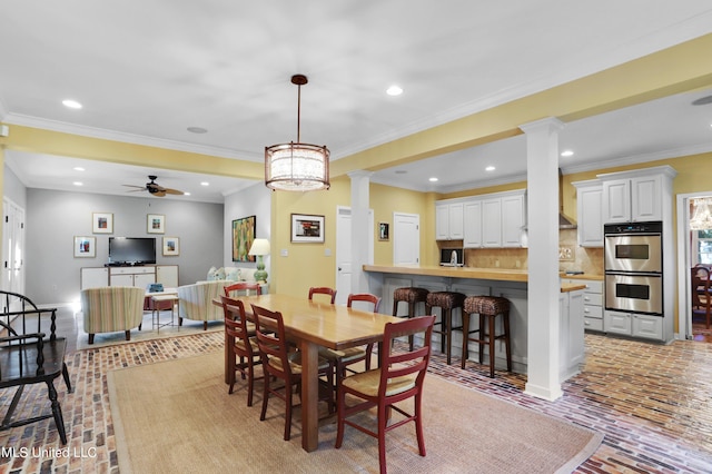 dining area with ornate columns, ornamental molding, and ceiling fan