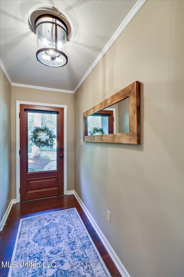 entryway with dark wood-style flooring, a textured ceiling, ornamental molding, and baseboards