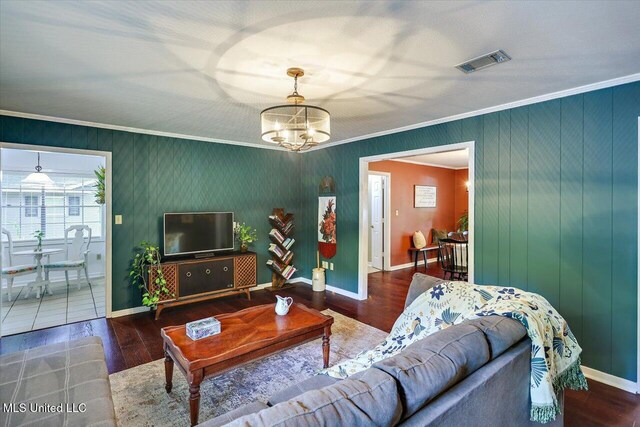 living room featuring ornamental molding, a chandelier, wood finished floors, and baseboards