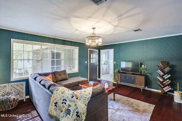 living room featuring a chandelier, wood-type flooring, ornamental molding, and baseboards