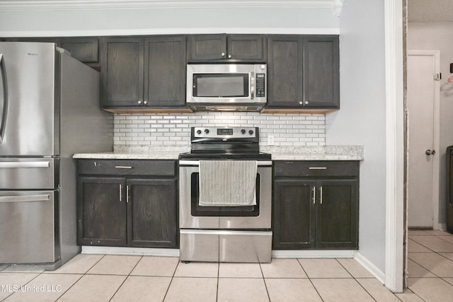 3306 Nottingham Rd, Ocean Springs, MS 39564 - kitchen featuring appliances with stainless steel finishes, light tile patterned floors, decorative backsplash, and crown molding