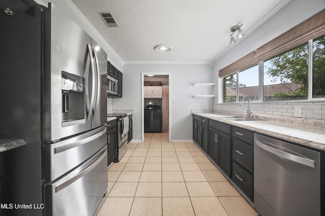 3306 Nottingham Rd, Ocean Springs, MS 39564 - kitchen featuring appliances with stainless steel finishes, dark cabinets, washer / dryer, decorative backsplash, and crown molding