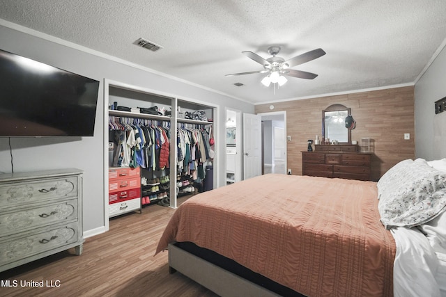 3306 Nottingham Rd, Ocean Springs, MS 39564 - bedroom with a closet, crown molding, a textured ceiling, wood finished floors, and ceiling fan