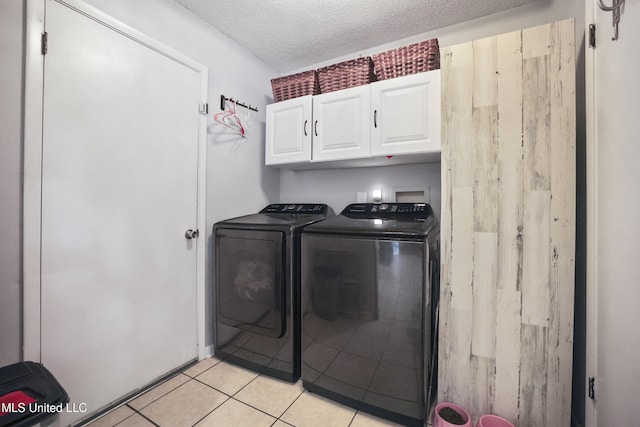 3306 Nottingham Rd, Ocean Springs, MS 39564 - washroom with cabinet space, washer and clothes dryer, a textured ceiling, and light tile patterned flooring