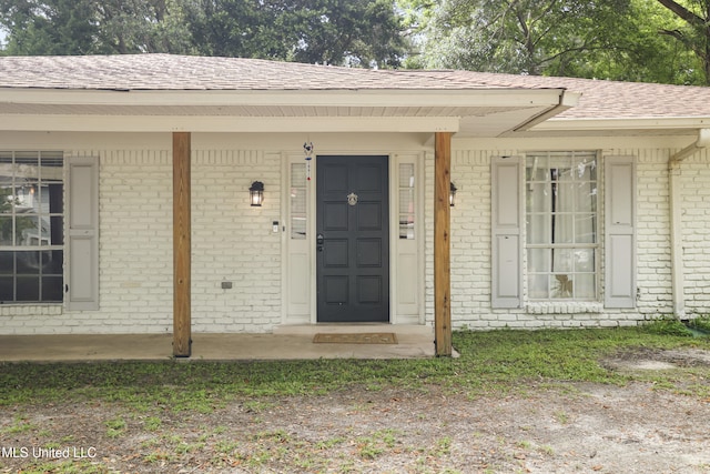 3306 Nottingham Rd, Ocean Springs, MS 39564 - property entrance featuring brick siding, roof with shingles, and covered porch