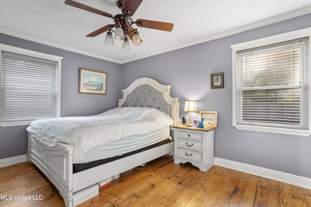 bedroom featuring crown molding, a textured ceiling, light hardwood / wood-style floors, and ceiling fan