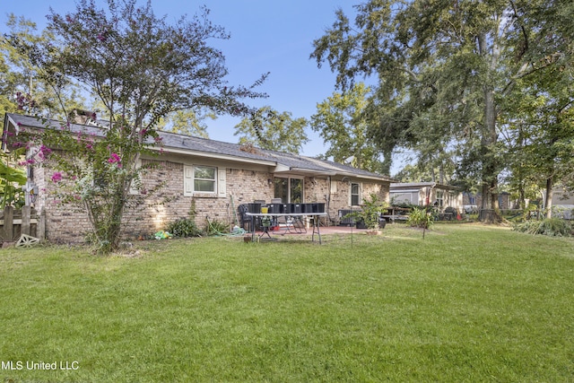 306 Jamaica Dr, Ocean Springs, MS 39564 - back of house featuring a lawn, a patio area, and brick siding