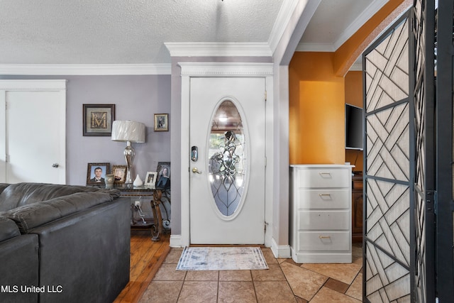 entrance foyer with ornamental molding, a textured ceiling, and light hardwood / wood-style floors