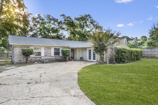 306 Jamaica Dr, Ocean Springs, MS 39564 - single story home featuring a front lawn, brick siding, concrete driveway, french doors, and fence