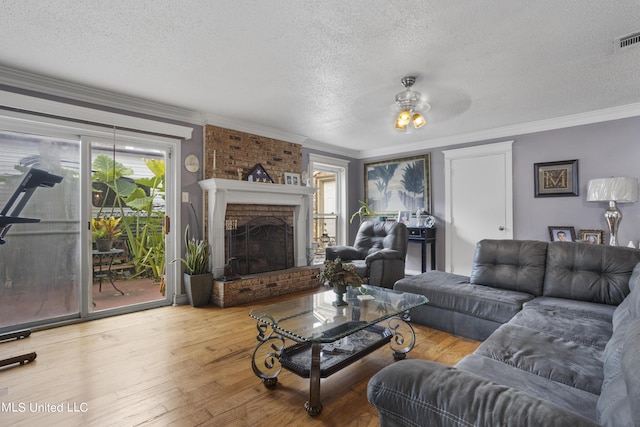 306 Jamaica Dr, Ocean Springs, MS 39564 - living room with a textured ceiling, hardwood / wood-style floors, ornamental molding, and a brick fireplace