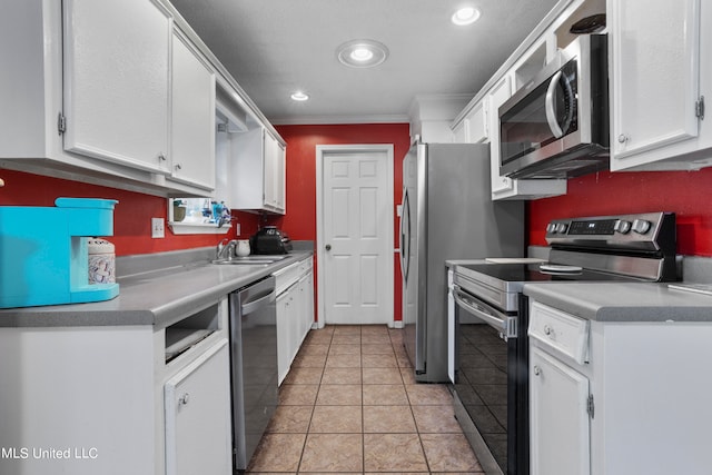 kitchen with crown molding, appliances with stainless steel finishes, white cabinets, and light tile patterned flooring