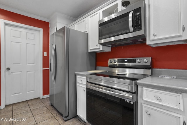 306 Jamaica Dr, Ocean Springs, MS 39564 - kitchen with crown molding, white cabinets, stainless steel appliances, light countertops, and light tile patterned flooring