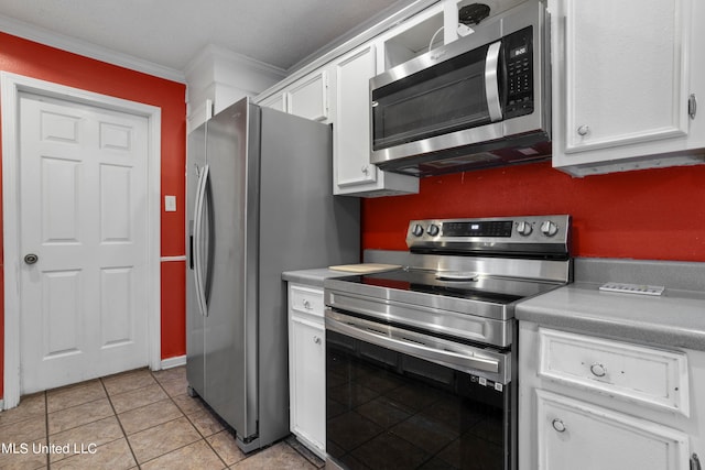 kitchen with crown molding, stainless steel appliances, light tile patterned flooring, and white cabinets