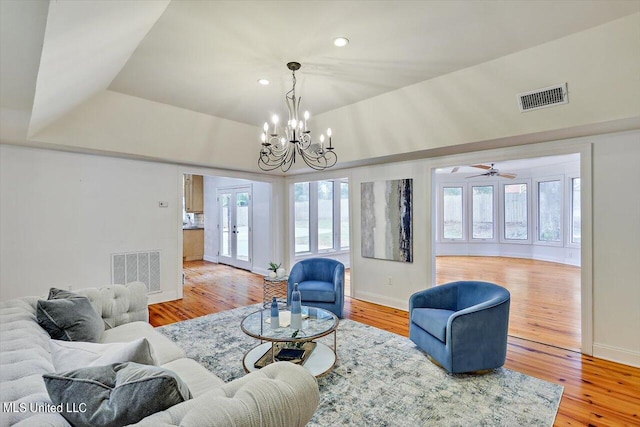 living room with french doors, ceiling fan with notable chandelier, and hardwood / wood-style floors