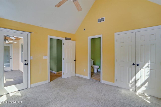 unfurnished bedroom featuring ensuite bath, a closet, light carpet, ceiling fan, and high vaulted ceiling