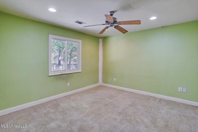 spare room featuring light carpet and ceiling fan