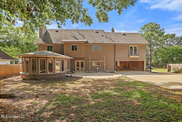 back of house featuring a garage, a patio, and a sunroom