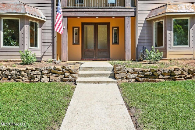 doorway to property with french doors and a lawn